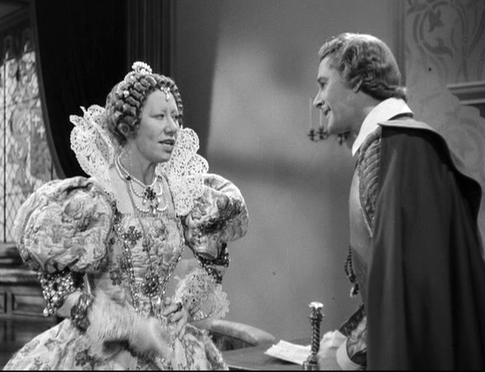 Queen Elizabeth I (Flora Robson) and Captain Thorpe (Errol Flynn) debate his next steps.