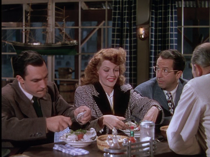 Gene Kelly, Rita Hayworth, and Phil Silvers search for pearls in their oysters.